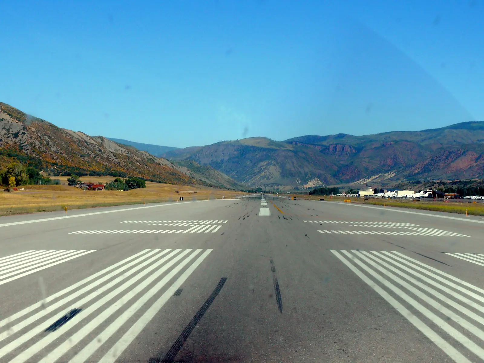 The runway at Aspen-Pitkin County Airport with mountains rising at the far end