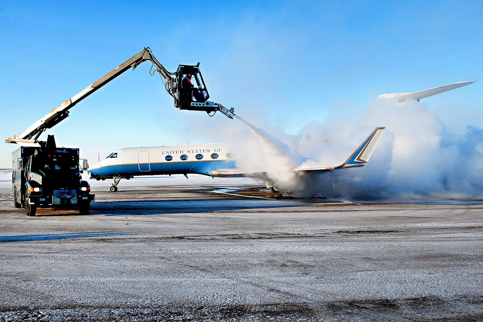 An aircraft being de-iced on a snowy ramp before departure