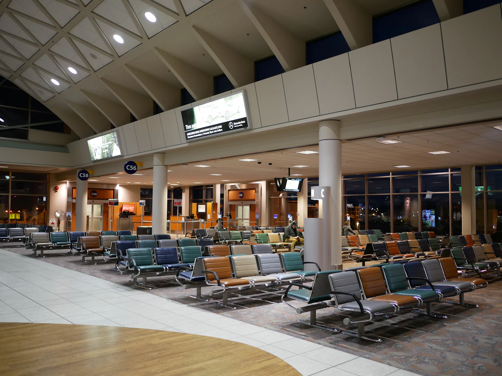 An empty departure gate with rows of seating at an airport terminal