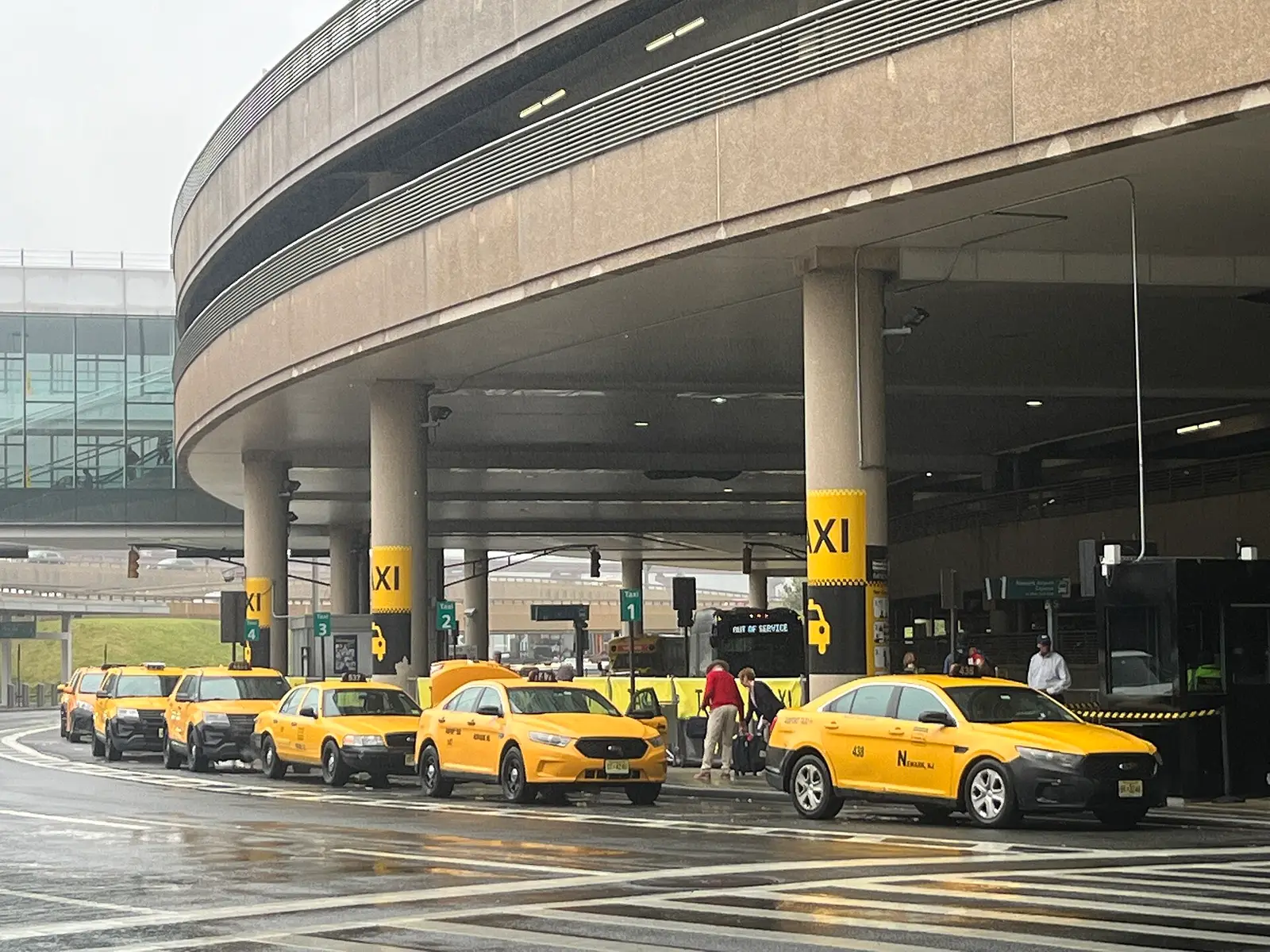 Yellow cabs at the curb outside a terminal at Newark Liberty International Airport