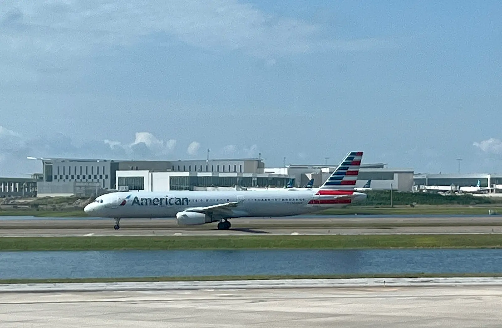 An American Airlines jet taxiing past the terminal at Orlando International Airport