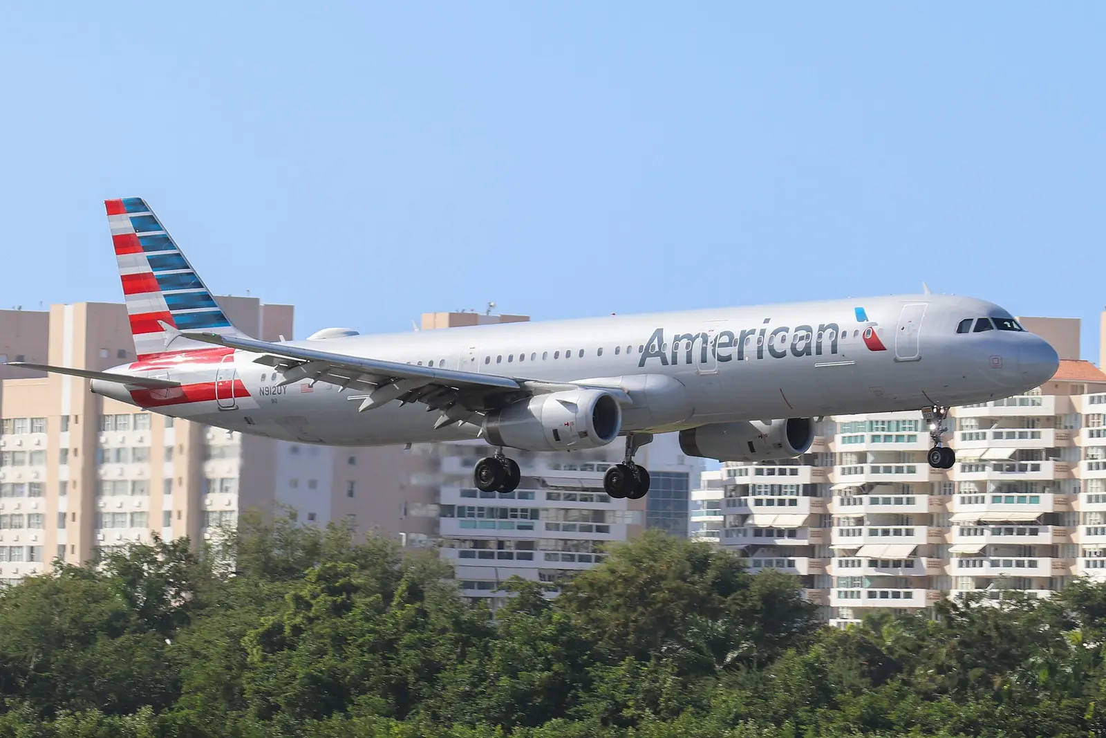 An American Airlines jet landing at San Juan with the Isla Verde apartment towers behind